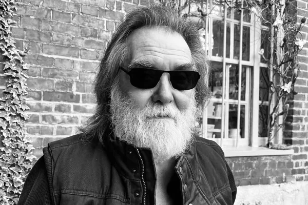 Dennis Locorriere de óculos escuros em foto preto e branco