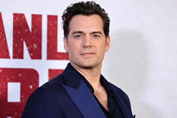 foto colorida de Henry Cavill de terno azul escuro sério - metrópoles
