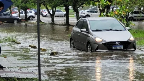 Imagem colorida de carro passando em uma rua alagada de Santa Catarina chuvas - Metrópoles