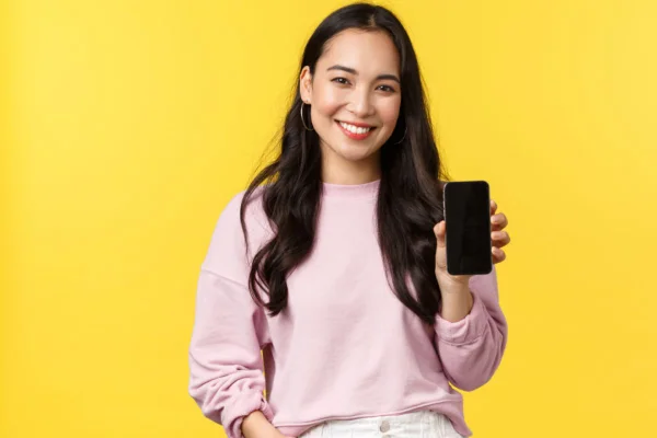 Mulher sorrindo segurando o celular para a foto