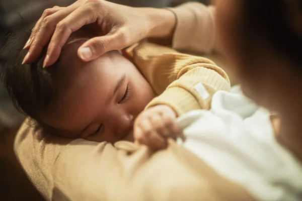 Bebê mamando aconchegado no colo da mãe