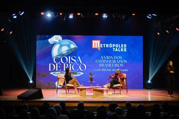 Fotografia colorida mostrando homem e mulher conversando em palco-Metrópoles