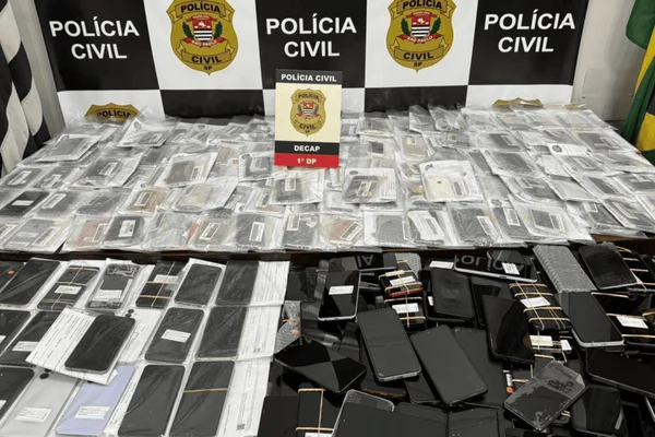 Imagem colorida de celulares em uma mesa da Polícia Civil - Metrópoles