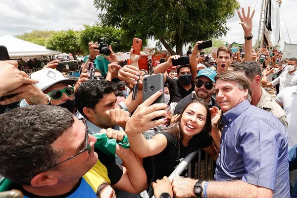 Sem máscara, Bolsonaro carrega criança e cumprimenta dezenas de apoiadores