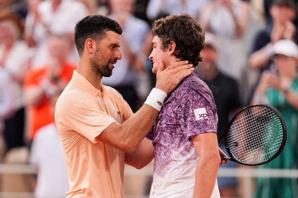 Imagem colorida de João Fonseca e Djokovic abraçados - Metrópoles