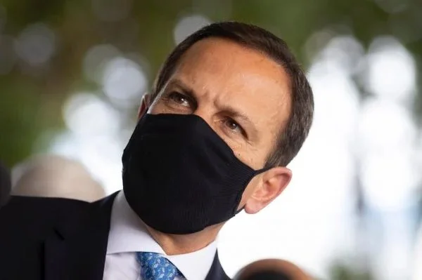 João Doria, governador de São Paulo. Ele veste terno e gravata e está de mascara - Metrópoles