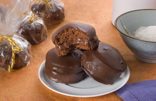 Pães de mel empilhados num pire e outros embalados em sacos em uma mesa com ingredientes - Metrópoles