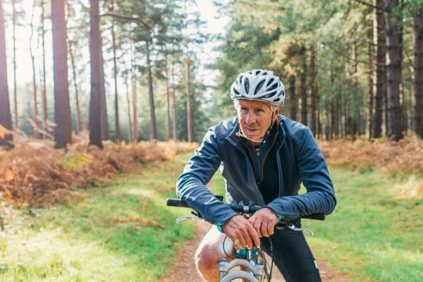 Homem andando de bicicleta. Ele usa capacete e roupa de ginástica azul - Metrópoles