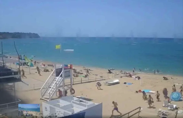 imagem colorida de pessoas correndo de míseis em praia da Crimeia - Metrópoles