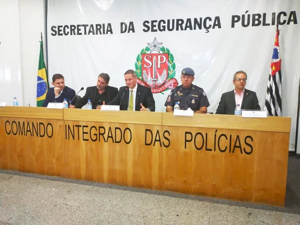 Imagem colorida mostra o secretário de segurança de São Paulo, Guilherme Derrite, no centro de uma mesa de cinco homens, integrantes da cúpula da segurança do estado - Metrópoles