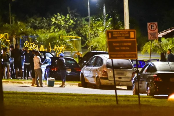 Estacionamento com jovens usando caixa térmica