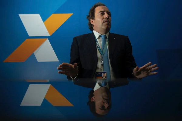 Homem de terno com logo da caixa atrás assédio caixa