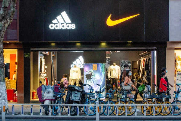 A imagem mostra a faixada de uma loja com as logos da Nike e Adidas lado a lado trump