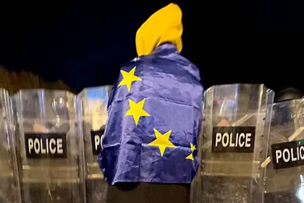 Imagem colorida, bandeira da União Europeia e à frente vários policiais - Metrópoles