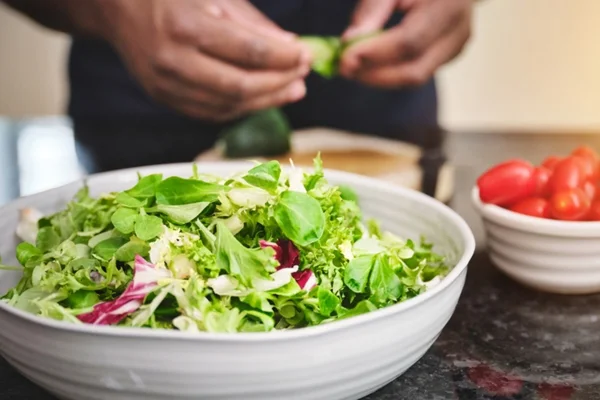 Homem preparando salada - Metrópoles