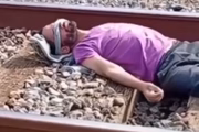 Homem deitado nos trilhos enquanto o trem passa sobre ele