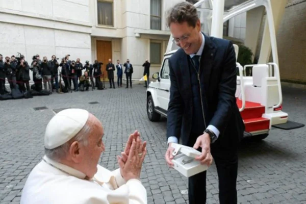 Imagem colorida de homem entregando novo papa móvel ao papa Francisco - Metrópoles