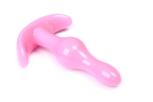 Foto colorida de um plug anal alongado cor-de-rosa em cima de uma superfície branca - Metrópoles