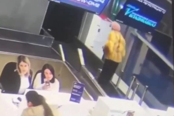 Foto colorida retirada de vídeo que mostra mulher de 74 anos em esteira de malas em aeroporto, na Rússia - Metrópoles