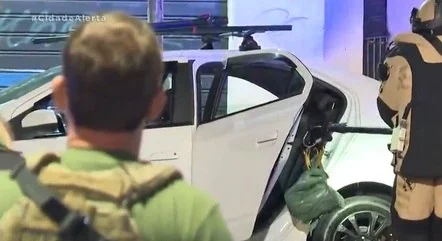 Imagem colorida mostra integrante do esquadrão antibomba recolhendo sacola com explosivos em carro no centro de São Paulo - Metrópoles