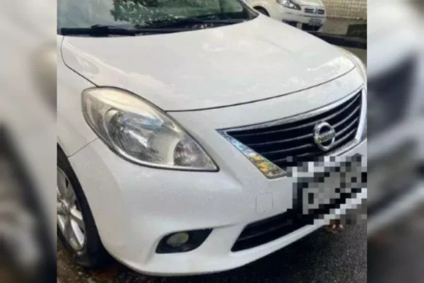 Parte frontal de carro branco, modelo Nissan Versa - Metrópoles