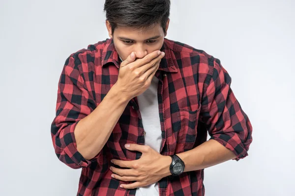 Um homem com dor de estômago, Colocando as mãos na barriga e cobrindo a boca- Metrópoles