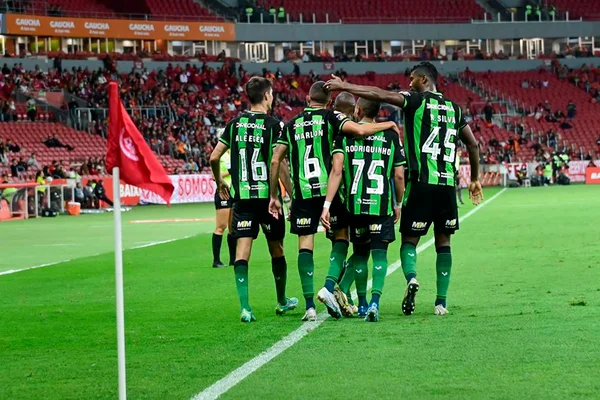 Imagem dos jogadores do América abraçados - Metrópoles