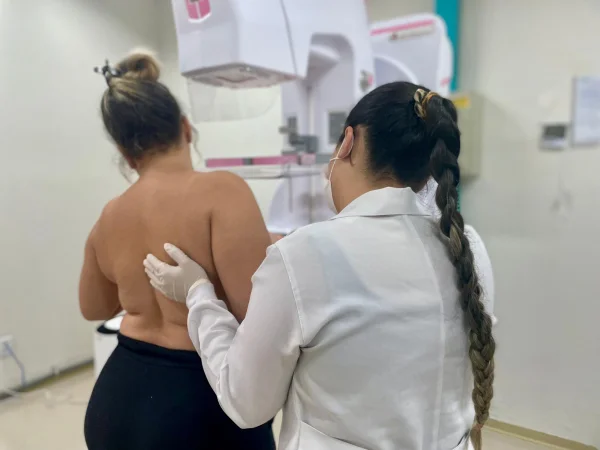 Fotografia colorida mostrando médica examinando mulher de costas-Metrópoles