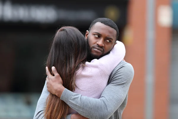 Imagem mostra homem abraçando mulher com cara de repulsa - Metrópoles