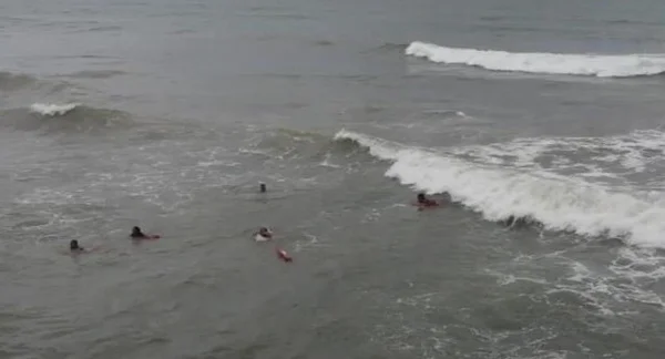 Foto colorida de cinco pessoas se afogando na praia de Abaís (SE) - Metrópoles