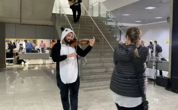 foto colorida de homem vestido de panda em aeroporto