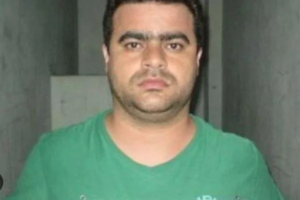 Homem branco de camiseta verde e semblante sério - Metrópoles