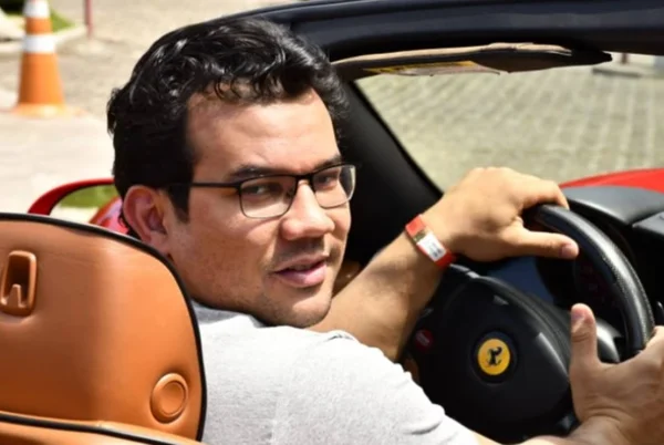 Homem posa ao volante de Ferrari