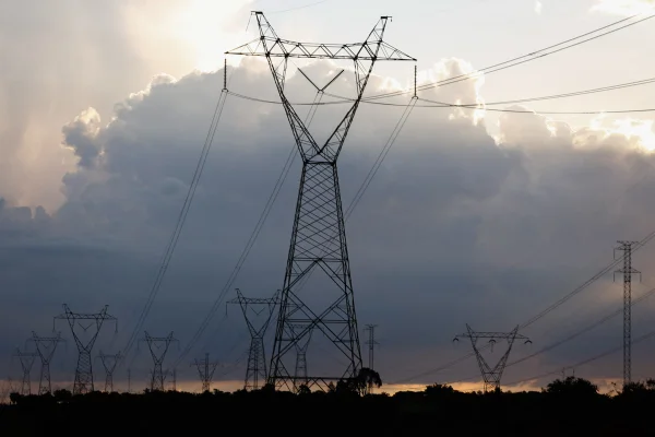 Linhas de transmissão de energia em horizonte com árvores - Metrópoles