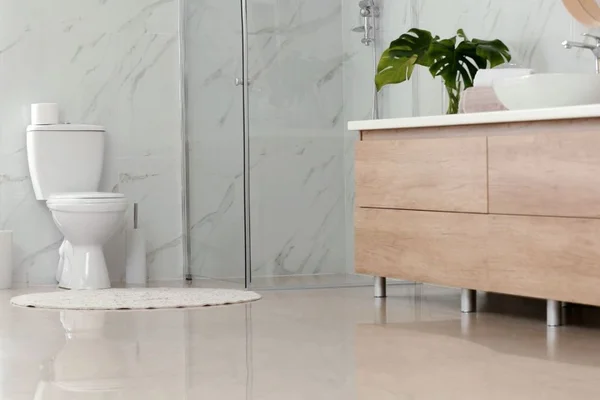 Banheiro branco com vaso e uma pia marrom