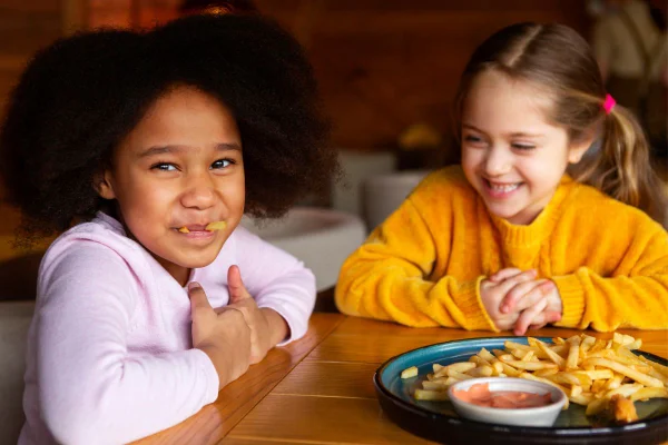Foto colorida de crianças comendo - Metrópoles