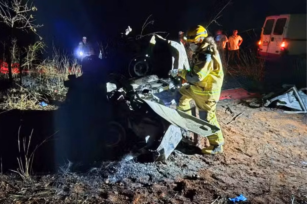 Foto colorida de bombeiro próximo às ferragens de carro - Metrópoles