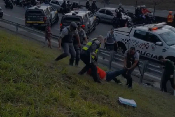 Imagem colorida de PMs agredindo homem que segurava cartaz de cartolina em protesto contra pedágios em Cotia (SP). - Metrópoles