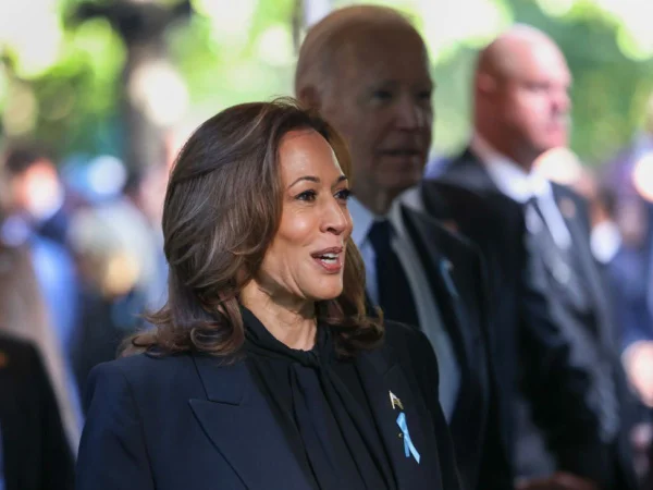 Foto colorida de Kamala Harris. Ao fundo Joe Biden - Metrópoles