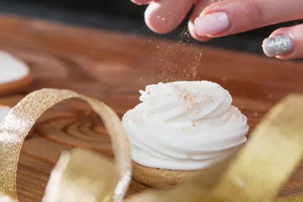Mão de mulher colocando glitter em cupcake - Metrópoles