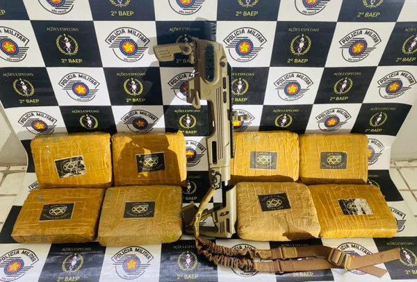 Imagem mostra drogas e arma em frente a banner da PM - Metrópoles