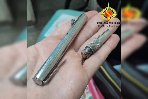 Caneta prata em mão de policial