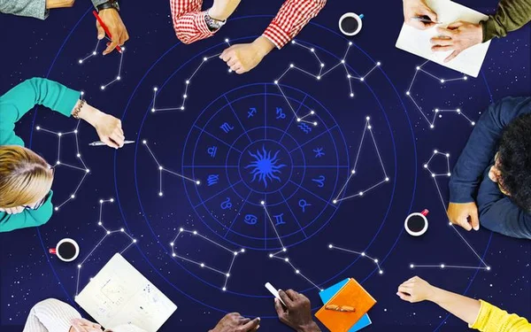 Na imagem, pessoas desenham as constelações dos signos