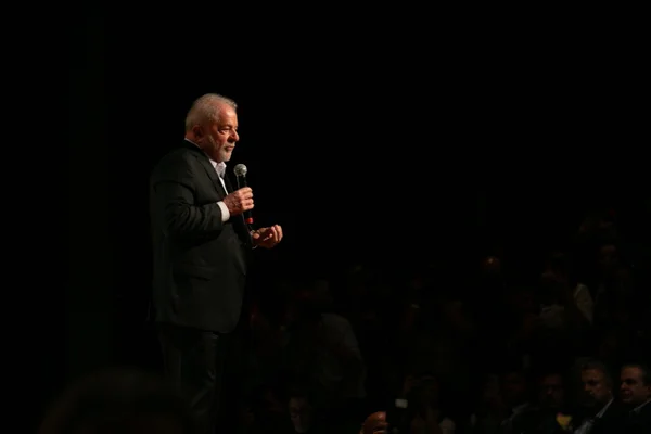 Imagem colorida mostra Luiz Inácio Lula da Silva, presidente eleito, em pé em um palco. Ele usa terno e segura um microfone - Metrópoles