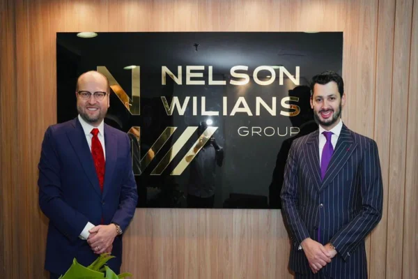 Representantes do Nelson Williams Group frente à placa do escritório - Metrópoles