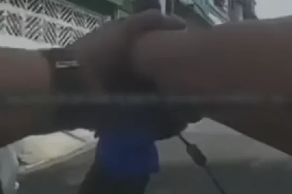 Imagem colorida de câmera corporal de PM com arma na mão. Metrópoles