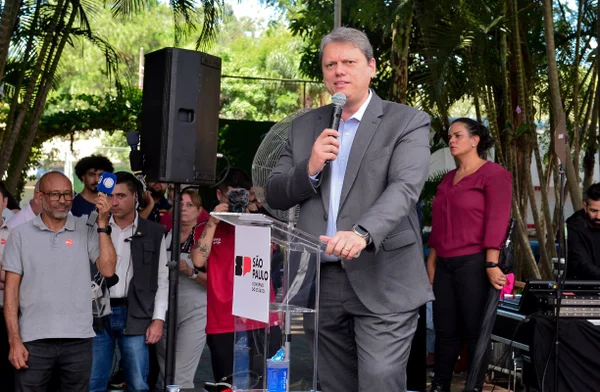 Imagem colorida mostra o governador Tarcísio de Freitas fazendo discurso em São Paulo; ele veste um terno cinza e uma camisa azul clara, sem gravata - Metrópoles