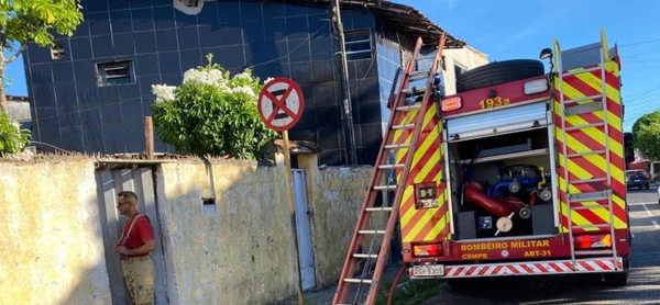 Imagem colorida de caminhão de bombeiros em frente a casa que pegou fogo - Metrópoles