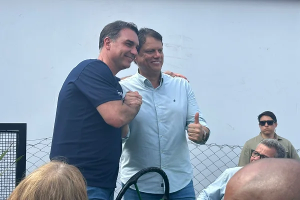 Imagem colorida de Flávio Bolsonaro junto com Tarcísio de Freitas. Metrópoles