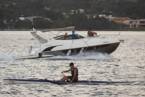 Lancha com pessoas circulando no Lago Paranoá e um banhista em um caiaque - Metrópoles